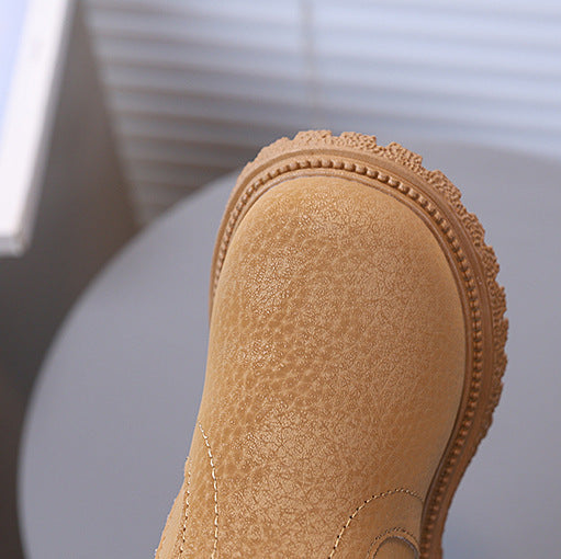 Close-up of a brown suede shoe with a blurred background