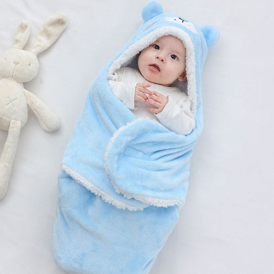 Baby wrapped in a blue swaddle with a white rabbit toy on a light gray background