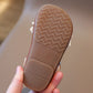 Close-up of a shoe sole with a wavy pattern held by a hand against a blurred background