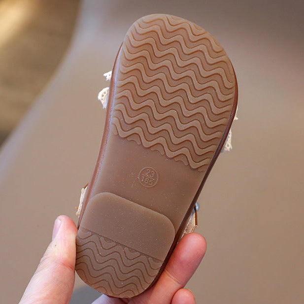 Close-up of a shoe sole with a wavy pattern held by a hand against a blurred background