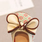 Shoe with a decorative bow on a neutral background