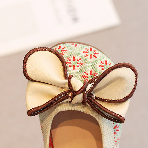 Shoe with a decorative bow on a neutral background
