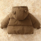 Brown puffer jacket with bear ears on a beige carpet