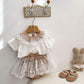 Children's outfit with lace top and shorts hanging . Brown and white combo