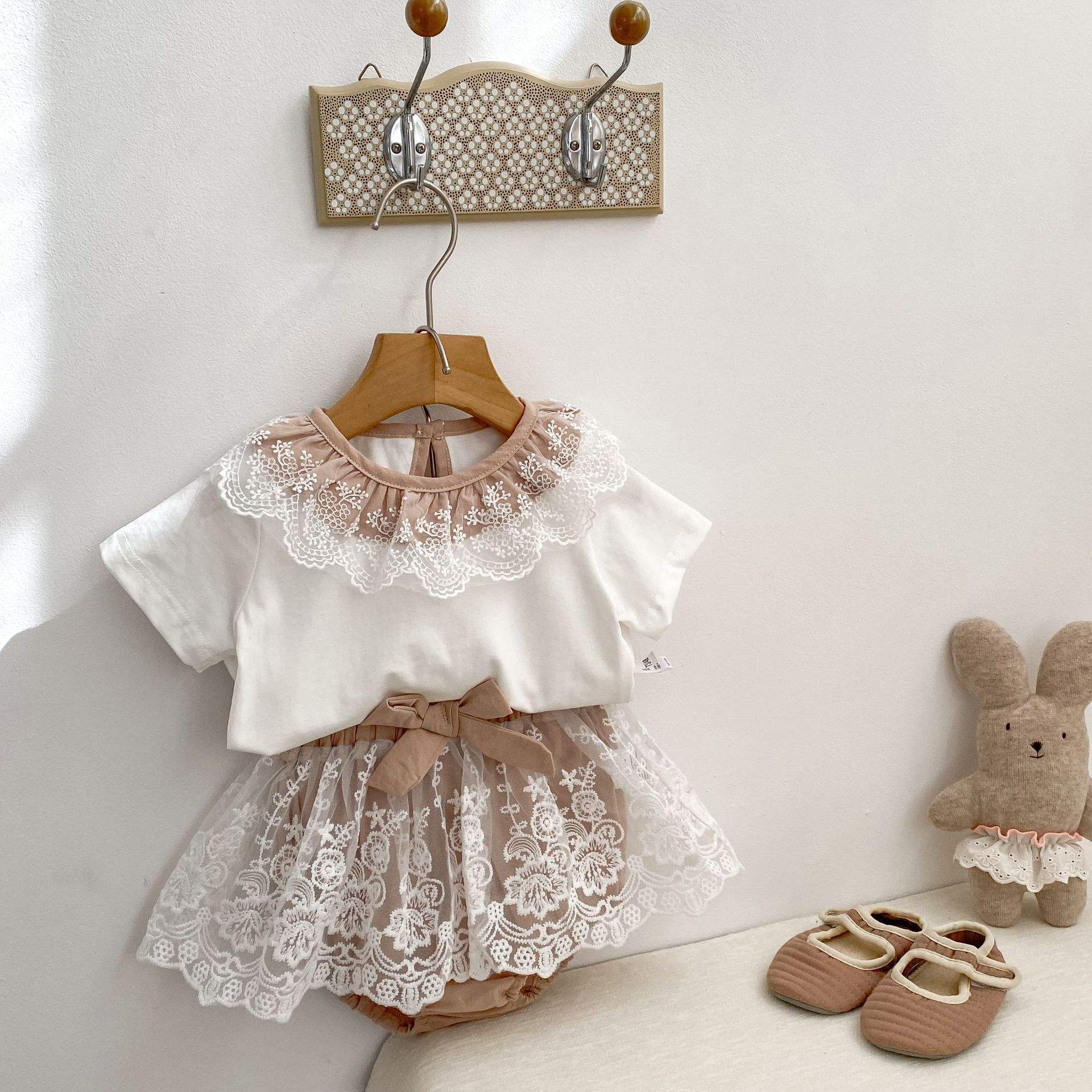Children's outfit with lace top and shorts hanging . Brown and white combo