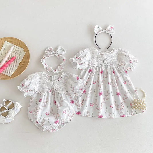 Baby girl's floral outfit with matching accessories on a white background.