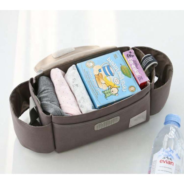 Brown organizer with baby items including books and clothes on a white surface.