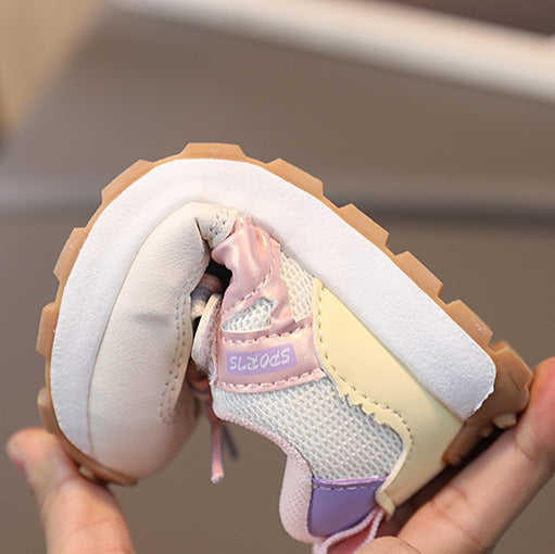Small child's shoe held in a hand with a blurred background
