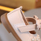 Close-up of a beige sandal with a strap on a blurred background