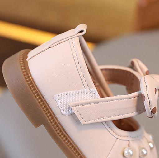 Close-up of a beige sandal with a strap on a blurred background