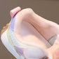 Close-up of a hand holding a colorful sneaker with a soft focus background