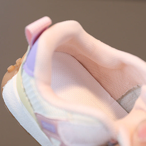 Close-up of a hand holding a colorful sneaker with a soft focus background