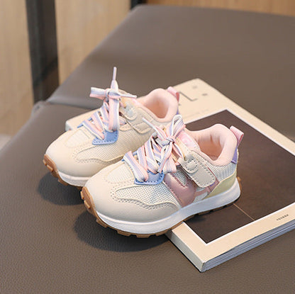 Pair of children's sneakers on a book with a blurred background