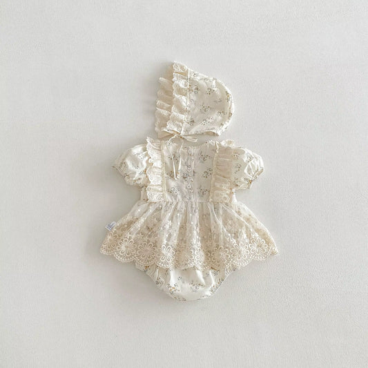 White lace baby romper with bonnet on a light gray background