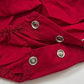 Close-up of red fabric with metal buttons on a white background