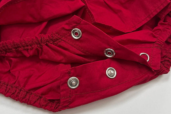 Close-up of red fabric with metal buttons on a white background