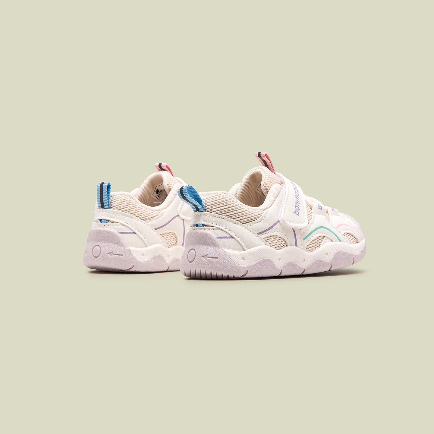 Pair of white sneakers with colorful accents on a light green background