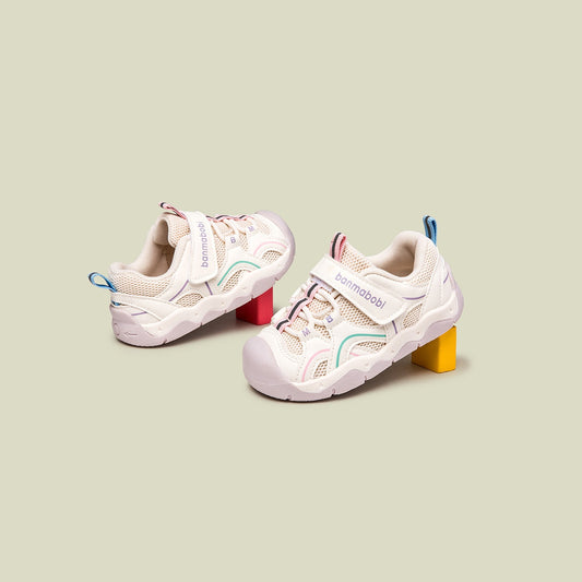 Pair of children's sneakers on a light green background