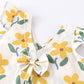 Floral-patterned fabric with yellow flowers and green leaves on a white background