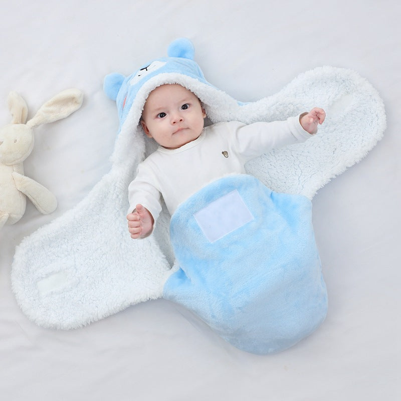Baby in a blue and white fluffy outfit with bear ears on a light gray background