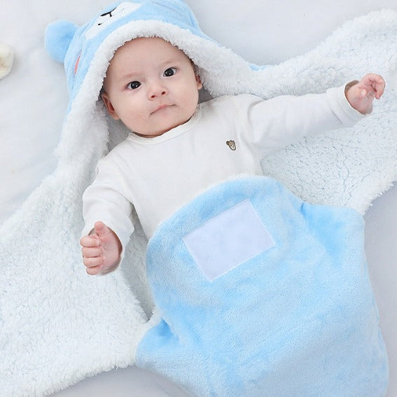 Baby wrapped in a blue and white fluffy blanket with a heart design.