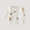 A white long-sleeve baby wrap jacket with a vertical ribbed texture and teddy bear prints, shown on a light gray background.