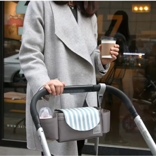 A baby stroller with a organizer in an urban setting.