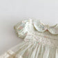 Vintage-style dress with floral patterns and lace details on a plain background