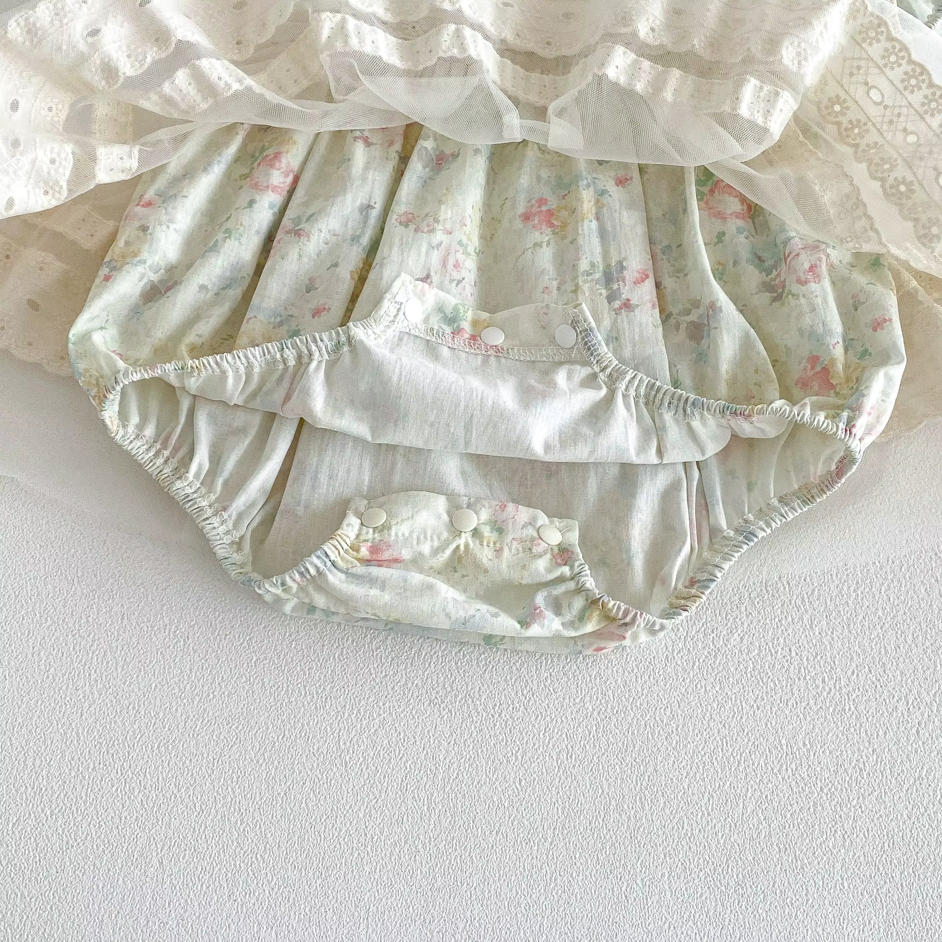 Floral-patterned baby bloomers on a white background